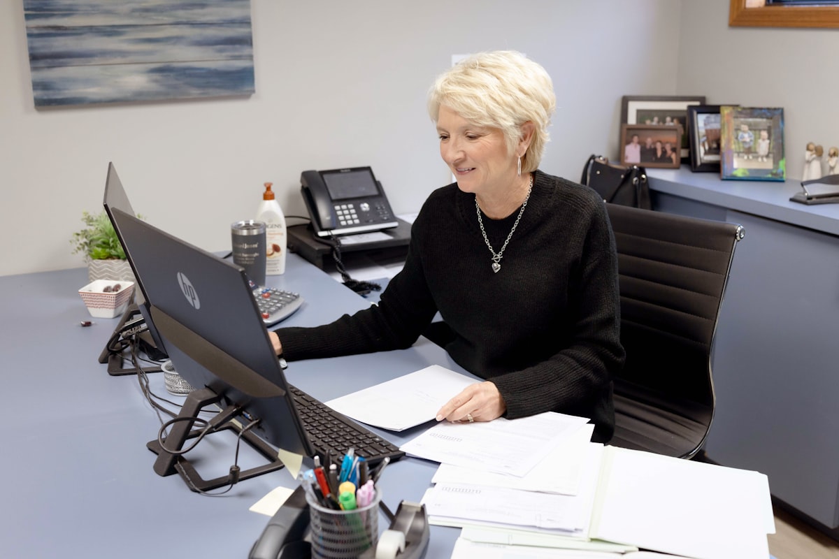 Facility administrator reviewing paperwork and schedules at her office desk